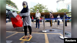 protective face mask while receiving rice from an automated rice ATM distributor amid the spread of the coronavirus disease (COVID-19) in Jakarta, Indonesia May 4, 2020. REUTERS/Ajeng Dinar Ulfiana