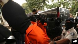 Police anti-terror unit escort suspected militants before a press conference in Jakarta, May 17, 2019. Police say they have arrested suspected militants following a tipoff about a possible attack during the announcement of presidential election results next week.