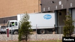 Truk yang membawa vaksin Covid-19 keluar dari fasilitas pabrik Pfizer di Portage, Michigan, Minggu (13/12). 