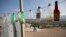 Empty bottles hang outside a beverage vendor's stall in Canaan, Haiti, June 21, 2015. 