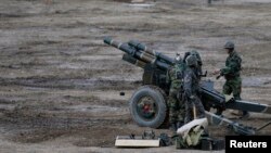 FILE - South Korean soldiers of an artillery unit check their armaments during a military drill near the demilitarized zone separating North Korea from the South, in Paju, north of Seoul.