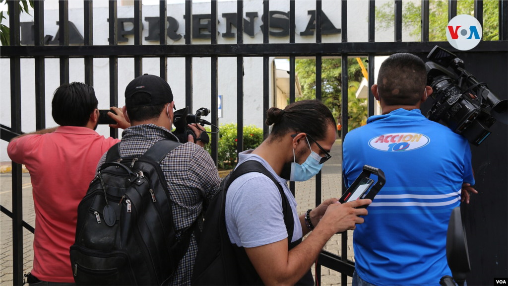 Periodistas dan cobertura al allanamiento del diario La Prensa desde las afueras del edificio. 