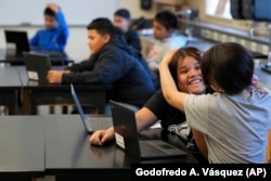 Alisson Ramírez, second from right, plays with a classmate during science class Wednesday, Aug. 28, 2024, in Aurora, Colo. (AP Photo/Godofredo A. Vásquez)