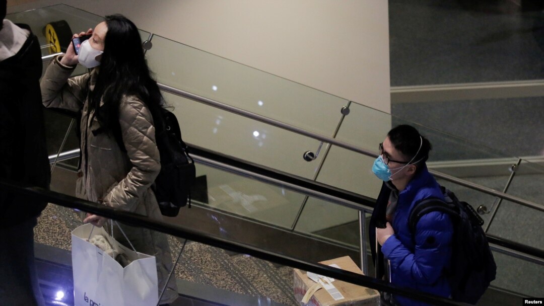 Para penumpang penerbangan langsung dari China mengenakan masker di Bandra International Seattle-Tacoma, di SeaTac, Washington, 23 Januari 2020.