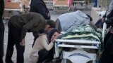 In this photo provided by Tasnim News Agency, relatives weep over the body of an earthquake victim, in Sarpol-e-Zahab, western Iran. Authorities reported that a powerful 7.3 magnitude earthquake struck the Iraq-Iran border region and killed more than 400 people in both countries, sent people fleeing their homes into the night and was felt as far west as the Mediterranean coast.