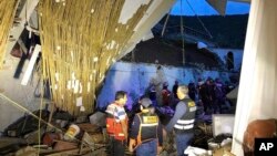 In this photo provided by Abancay police, officers and firefighters stand by a collapsed area of the Alhambra hotel in Abancay, Peru, Jan. 27, 2019. 
