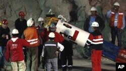 Rescue workers and officials maneuver the capsule that will be used to extract 33 trapped miners one by one from the collapsed San Jose Mine near Copiapo, Chile, 12 Oct. 2010