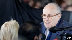 ARCHIVO - El exalcalde de la ciudad de Nueva York, Rudy Giuliani, habla con los dolientes antes de un funeral en la Biblioteca Billy Graham para el reverendo Billy Graham, el 2 de marzo de 2018, en Charlotte, Carolina del Norte.