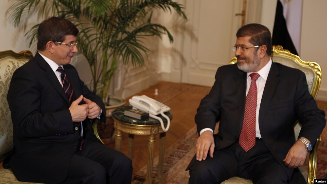 FILE - Former Egyptian President Mohamed Morsi (R) meets with Turkey's Foreign Minister Ahmet Davutoglu at the presidential palace in Cairo, Sept. 17, 2012. 