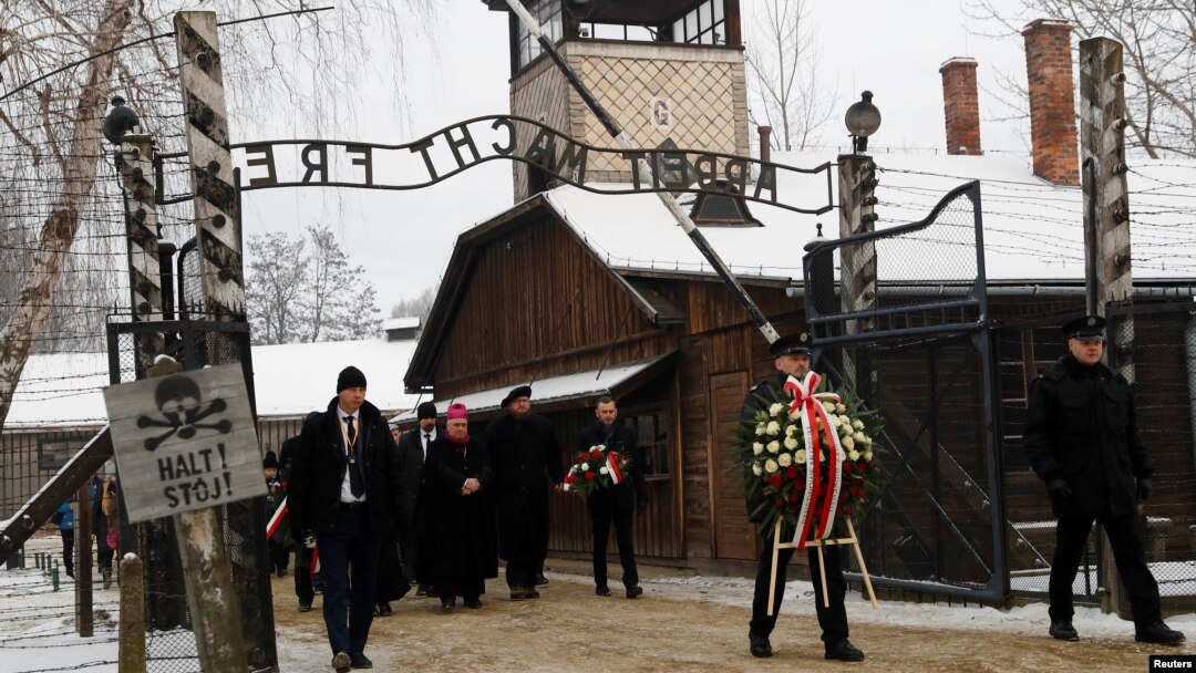 FILE - People arrive to lay wreaths at the "death wall" at the former Nazi German concentration and extermination camp Auschwitz, during the ceremonies marking the 74th anniversary of the liberation of the camp and International Holocaust Victims Remembrance Day