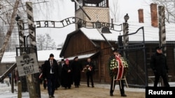 FILE - People arrive to lay wreaths at the "death wall" at the former Nazi German concentration and extermination camp Auschwitz, during the ceremonies marking the 74th anniversary of the liberation of the camp and International Holocaust Victims Remembrance Day