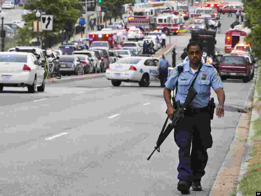 A Metropolitan Police Department officer walks near the Washington Navy Yard after at least one gunman launched an attack inside the Washington Navy Yard, Sept. 16, 2013.