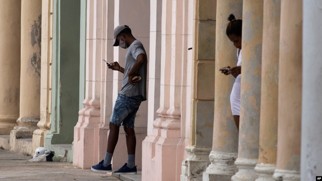 Dos personas consultan sus celulares en el malecón de La Habana, el 14 de julio de 2021.