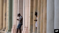 Cubanos usan sus teléfonos celulares desde una conexión wifi pública cerca del malecón en La Habana, Cuba, el martes 14 de julio de 2021.