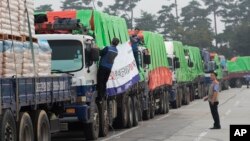 FILE - South Korean trucks with food aid prepare to leave for the North Korean city of Kaesong in Paju, South Korea, Sept. 21, 2012. 