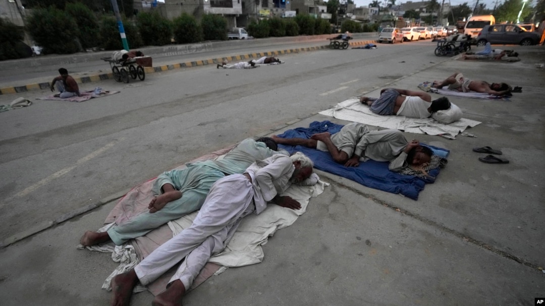 Para buruh tidur di pinggir jalan pada pagi hari musim panas yang terik di Karachi, Pakistan (29/5). Gelombang udara panas sedang melanda India dan Pakistan. 