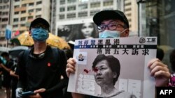 Seorang pengunjuk rasa memegang poster begambar Pemimpin Eksekutif Hong Kong Carrie Lam di kawasan perbelanjaan terkenal, Causeway Bay, di Hong Kong, 31 Agustus 2019. 