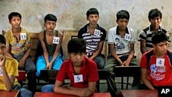 Young Indian bonded child laborers wait to be processed at a safe house after being rescued during a raid by workers from Bachpan Bachao Andolan, or Save the Childhood Movement, at a factory in New Delhi, India, June 11, 2013. 