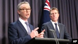 FILE - Australian Government Leader in the House of Representatives Christopher Pyne, left, and Attorney-General Christian Porter address reporters in Parliament House in Canberra, May 9, 2018.