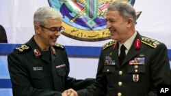 Kepala angkatan bersenjata Turki, Jenderal Hulusi Akar (kanan) diterima Panglima militer Iran Jenderal Mohammad Hossein Bagheri, di Teheran, Senin (2/10). 