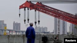 A worker stands on a dock next to the Huangpu river in Shanghai, November 25, 2014.