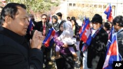 Cambodia's Ambassador to Washington DC, Hem Heng, far left, joins in to celebrate the flag ceremony in Philadelphia. 