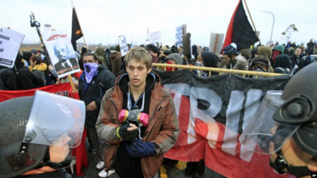 A protester faces a line of riot police during the Occupy movements' attempt to shut down west coast ports in Long Beach, California, December 12, 2011.