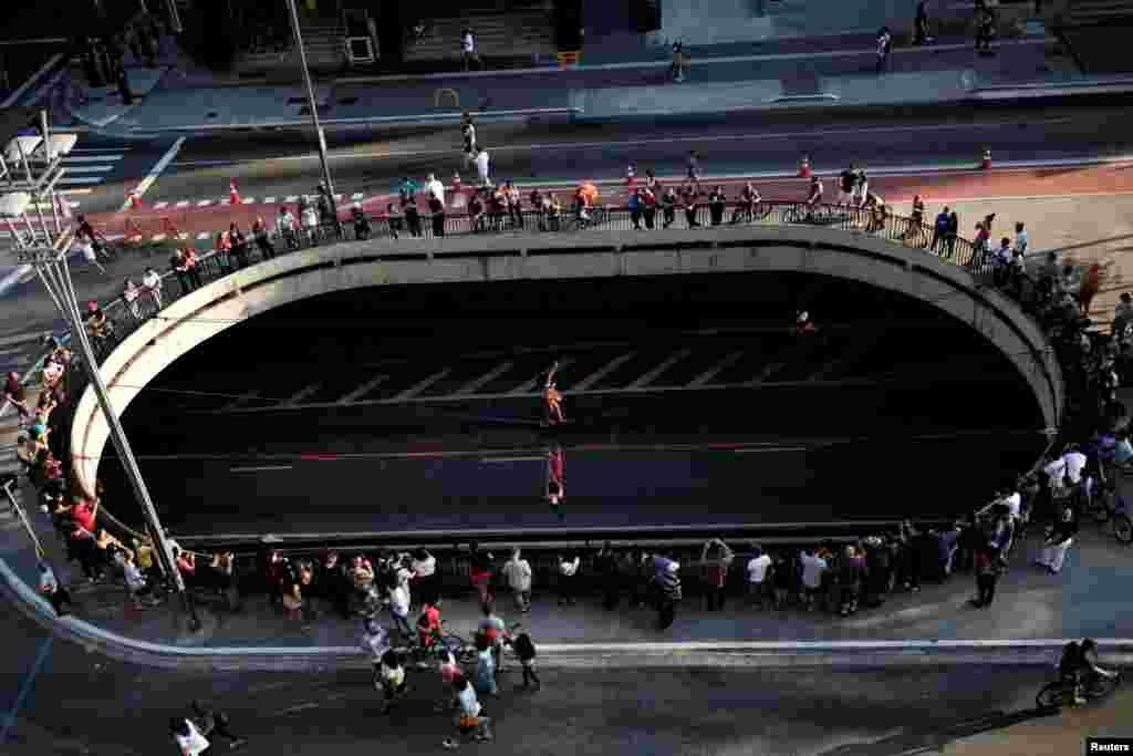 Women practice slacklining on Paulista Avenue in Sao Paulo, Brazil May 6, 2018. 