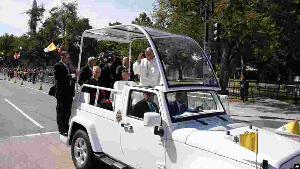 Le pape François, à bord de la Papa mobile, bénit la foule qui le salue, à Washington 