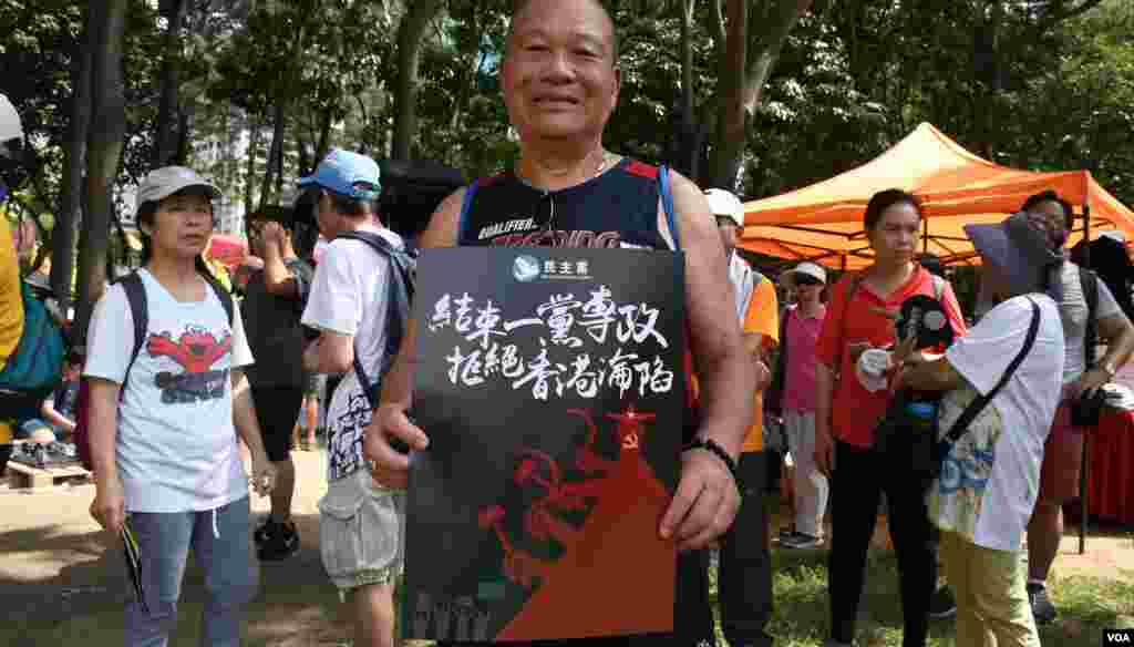 香港市民鍾先生手持遊行標語。(美國之音湯惠芸拍攝)