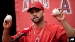 Albert Pujols muestra las pelotas de los jonrones 499 y 500, bateados contra los Nacionales de Washington.