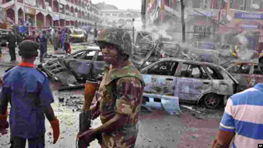 Un soldat nigérian, centre, marche sur les lieux d&#39;une explosion à Abuja, au Nigeria. Boko Haram a été accusé pour cet attentat qui a couté la vie à des dizaines de personnes à Maiduguri, lieu où le groupe islamiste extrémiste est né. (AP Photo / Olamikan Gbemiga, File) 