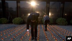 Chinese workers light candles before a vigil to mark China's first National Memorial Day at the Nanjing Massacre Memorial Hall in Nanjing in eastern China's Jiangsu province on Saturday, Dec. 13, 2014.