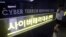 FILE - A woman walks by a sign at Cyber Terror Response Center of National Police Agency in Seoul, South Korea. 
