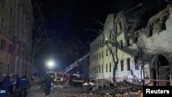 Rescuers and police officers work at a site of a residential building heavily damaged by a Russian missile strike, amid Russia's attack on Ukraine, in Kharkiv, Ukraine, Jan. 17, 2024.