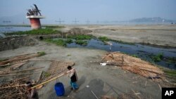 FILE—Two men carry water from Brahmaputra River on World Water Day in Guwahati, India, March 22, 2024.