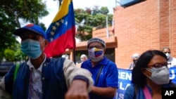 La gente se reúne frente a las oficinas de la Organización Panamericana de la Salud y la Organización Mundial de la Salud, durante una pequeña protesta exigiendo que las vacunas COVID-19, en Caraca, el 9 de septiembre de 2021.