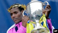 Lelisa Desisa, of Ethiopia, lifts his trophy after winning the Boston Marathon, Monday, April 20, 2015 in Boston. (AP Photo/Elise Amendola)