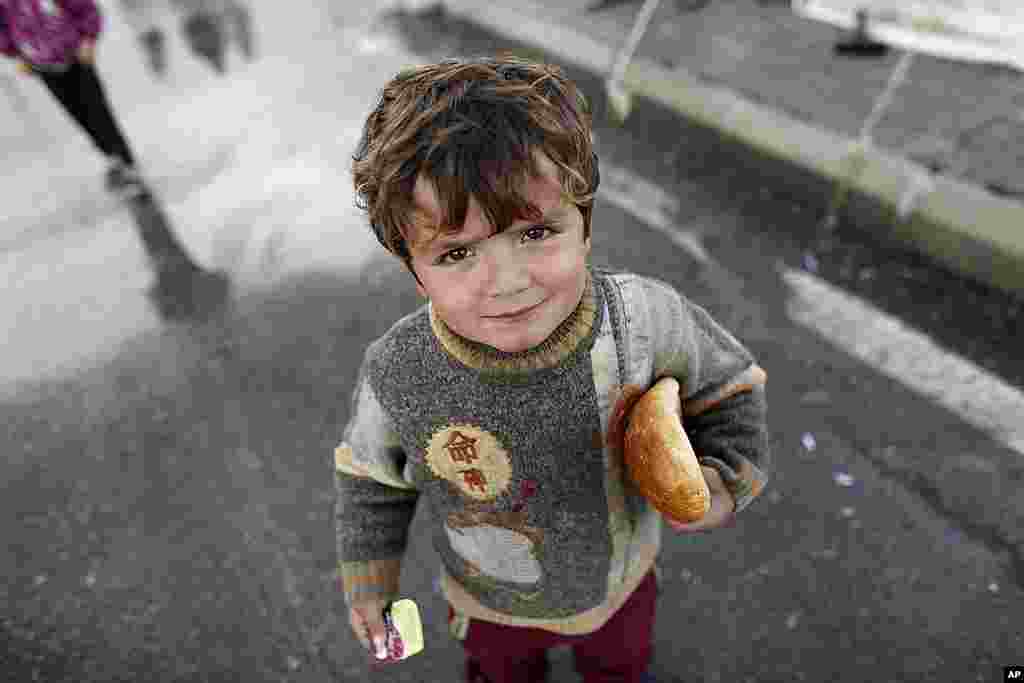 A Syrian refugee boy holds bread at the Boynuyogun refugee camp on the Turkish-Syrian border in Hatay province February 8, 2012. (Reuters)