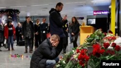 Relatives of the flight crew of the Ukraine International Airlines Boeing 737-800 plane that crashed in Iran, mourn at a memorial at the Boryspil International Airport outside Kyiv, Ukraine, Jan. 8, 2020. 