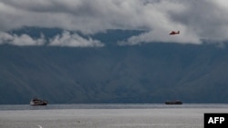 Helikopter tim SAR mencari korban kapal feri KM Sinar Bangun yang tenggelam saat berlayar di tengah cuaca buruk di Danau Toba pada 18 Juni lalu, Danau Toba, 23 Juni 2018.