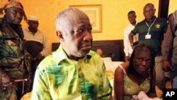 Tsohon shugaban Ivory Coast Laurent Gbagbo (hagu) da matarsa Simone Gbagbo a zaune (dama) a lokacin da ake musu shari'a