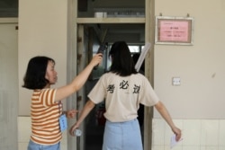 A student is checked with a metal detector before she enters a classroom for the annual national college entrance examination, or "gaokao", in Yangzhou, Jiangsu province, China, June 7, 2018.