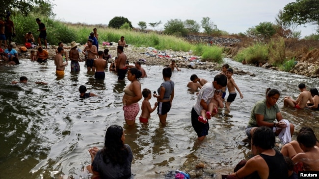 Migrants traveling in a caravan to reach the U.S. border through Mexico bathe in a river, in Mapastepec, Mexico, Dec. 29, 2023