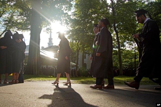 FILE - Graduates walk at a Harvard Commencement ceremony held for the classes of 2020 and 2021, May 29, 2022, in Cambridge, Mass. (AP Photo/Mary Schwalm, File)