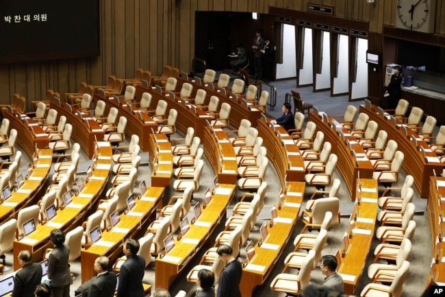 Anggota parlemen Ahn Cheol-soo duduk sendirian, satu-satunya wakil Partai Kekuatan Rakyat yang tersisa di ruang pemungutan suara, saat sesi pleno usulan pemakzulan Presiden Yoon Suk Yeol di Majelis Nasional, Seoul, 7 Desember 2024. (Jeon Heon-kyun/Pool Photo via AP)