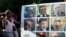 An anti-government protester throws an egg at a poster of Tunisian politicians, including Prime Minister Ali Larayedh (top row, C) and leader of the Islamist Ennahda movement Rached Ghannouchi (centre row, R) during a demonstration in Tunis October 2, 2013