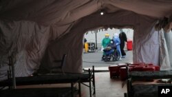 os médicos atienden a un paciente infectado por el nuevo coronavirus en una unidad de cuidados intensivos en el hospital del Seguro Social en Quito, Ecuador, el miércoles 29 de julio de 2020.