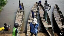 A river taxi driver dons a mask on the banks of the Sobat River in the town of Canal, currently filled with southern soldiers, many of whom are involved in military operations against rebels, April 6, 2011