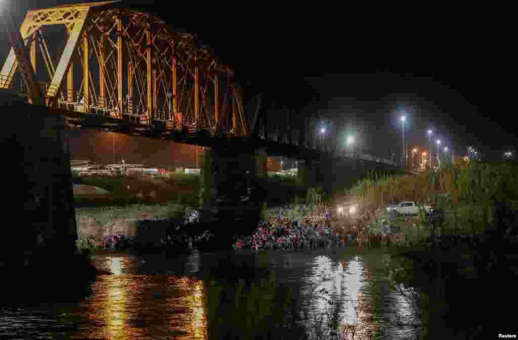 Asylum seekers wait on the banks of the Rio Bravo river after crossing during their journey through Mexico to Eagle Pass, Texas, in Piedras Negras, Mexico, Sept. 26, 2023.